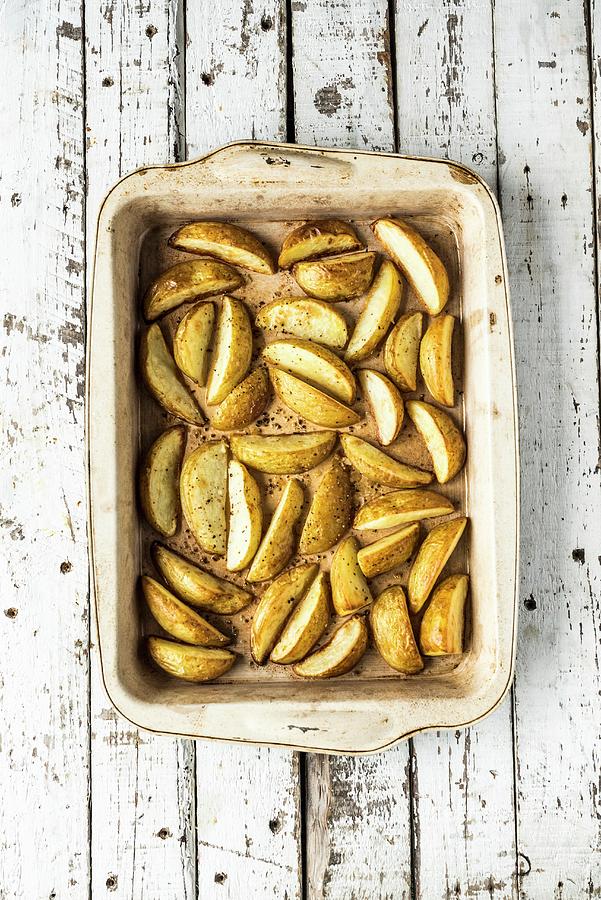 Potato Wedges In A Roasting Dish Photograph by Hein Van Tonder