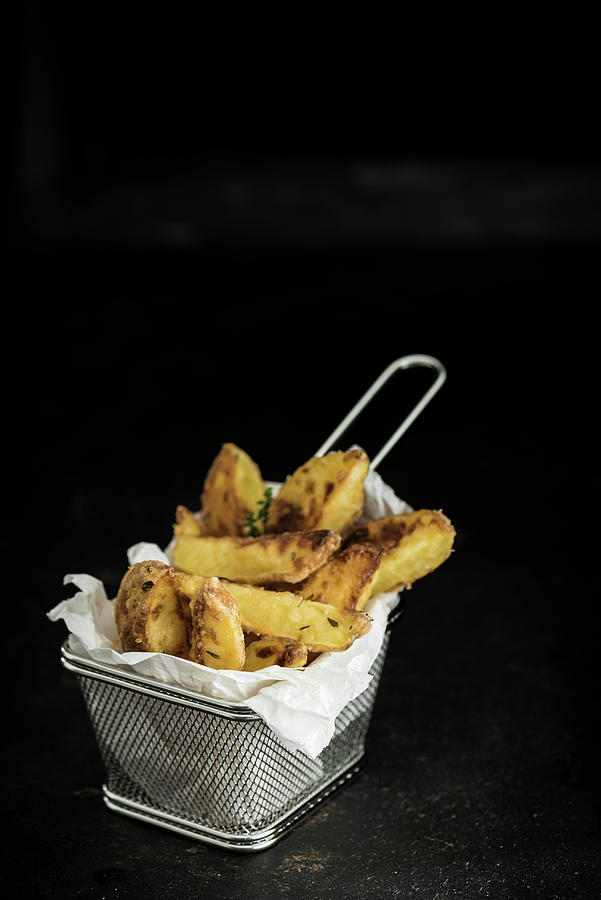 Potato Wedges With Thyme And Parmesan Cheese In A Frying Basket Photograph by M. Nlke