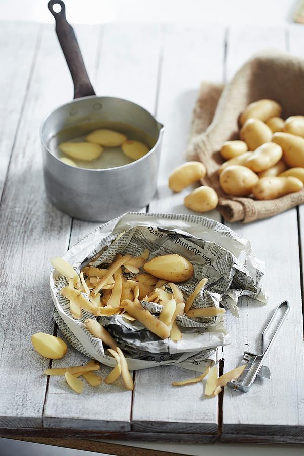 Potatoes, Some Partially Peeled And Some In A Pot Of Water Photograph by Rafael Pranschke