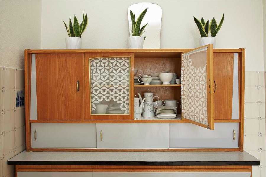 Potted House Plants On 50s Kitchen Dresser With Open Door Showing White Crockery Inside Photograph by Lioba Schneider Fotodesign