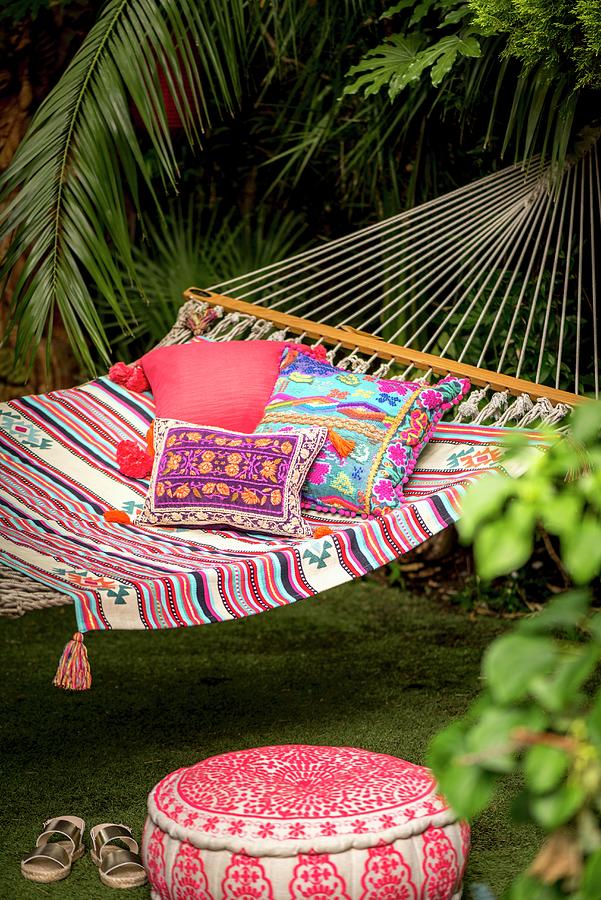 Pouffe Below Cushions With Ethnic Patterns In Hammock In Exotic Garen Photograph by Winfried Heinze