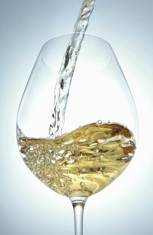 Pouring White Wine Into A Glass Photograph by Peter Garten