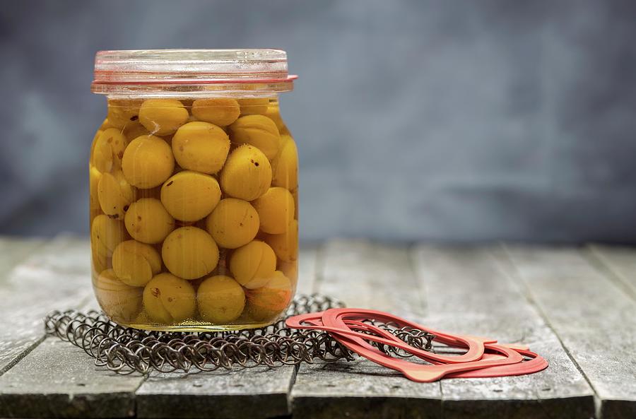 Preserved Small Yellow Plums In A Glass Jar Photograph by Nils Melzer