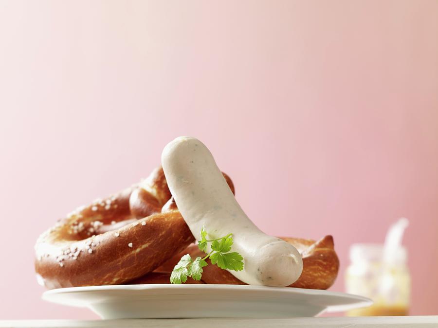 Pretzels And A White Sausage; In The Background A Jar Of Mustard Photograph by Studio R. Schmitz