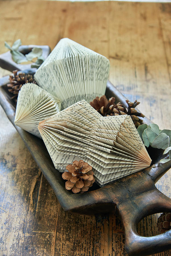 Prism-shaped Christmas Decorations Made From Folded Book Pages And Pine Cones In Wooden Dish Photograph by Inge Ofenstein