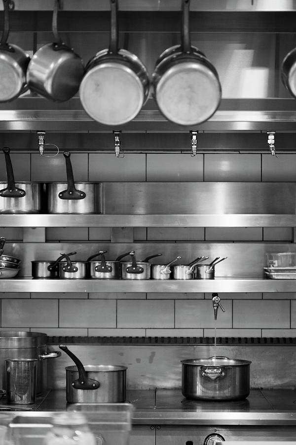 Professional Kitchen With Various Sizes Of Pots Hanging And On Shelves Ready To Be Used Photograph by Jennifer Martine