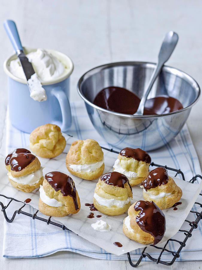 Profiteroles A La Creme On Rack With Melted Chocolate And Cream Photograph by Michael Paul