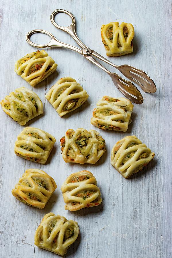 Puff Pastries Filled With Herb And Cream Cheese With A Pair Of Pastry Tongs Photograph by Charlotte Von Elm