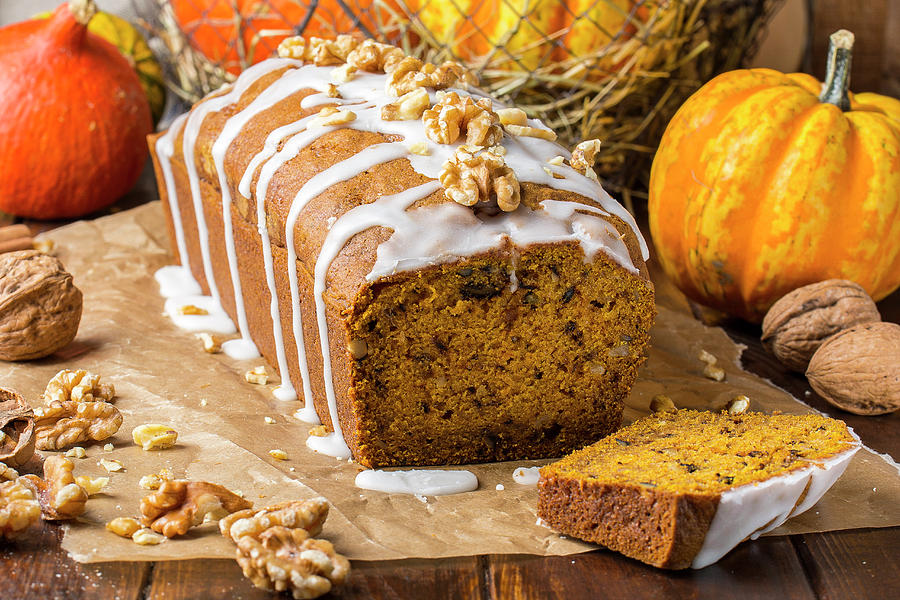 Pumpkin And Walnut Banana Bread On Baking Paper With Icing Photograph by Christian Kutschka