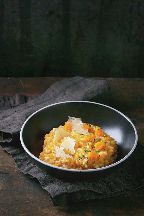 Pumpkin Risotto With Thyme And Cheese On A Dark Surface Photograph by Natasha Breen