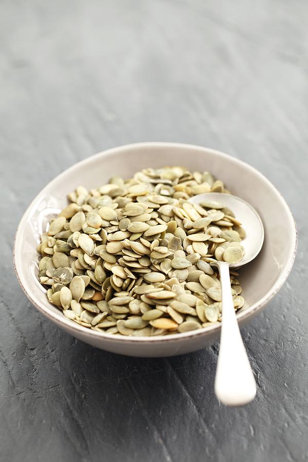 Pumpkin Seeds In A Bowl With A Spoon Photograph by Rua Castilho