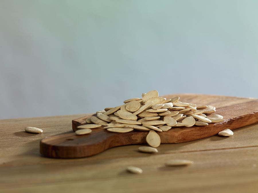 Pumpkin Seeds On A Chopping Board Photograph by Studio R. Schmitz