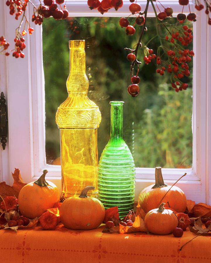 Pumpkins, Coloured Bottles & Rose Hip Branches At Window Photograph by Friedrich Strauss
