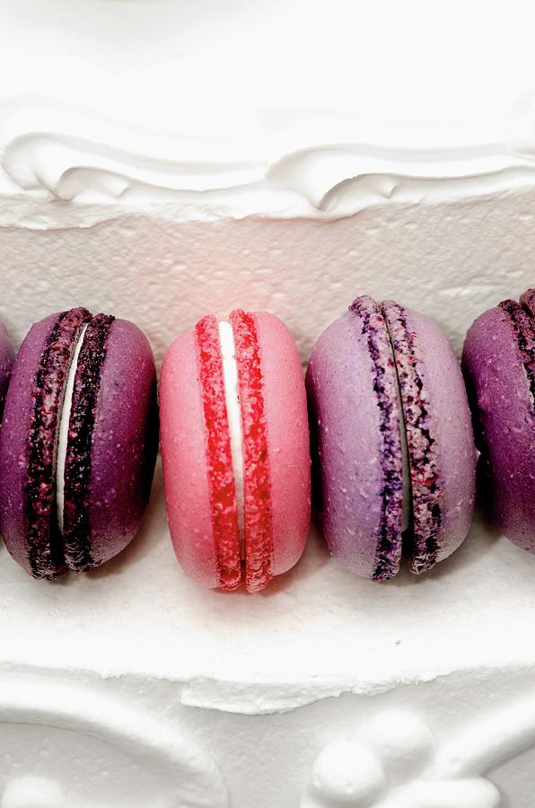 Purple And Pink Macaroons On A White Cream Layer Cake Photograph by Jamie Watson