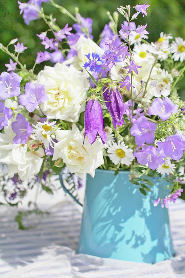Purple And White Flowers In Enamel Jug On Garden Table Photograph by Angela Francisca Endress