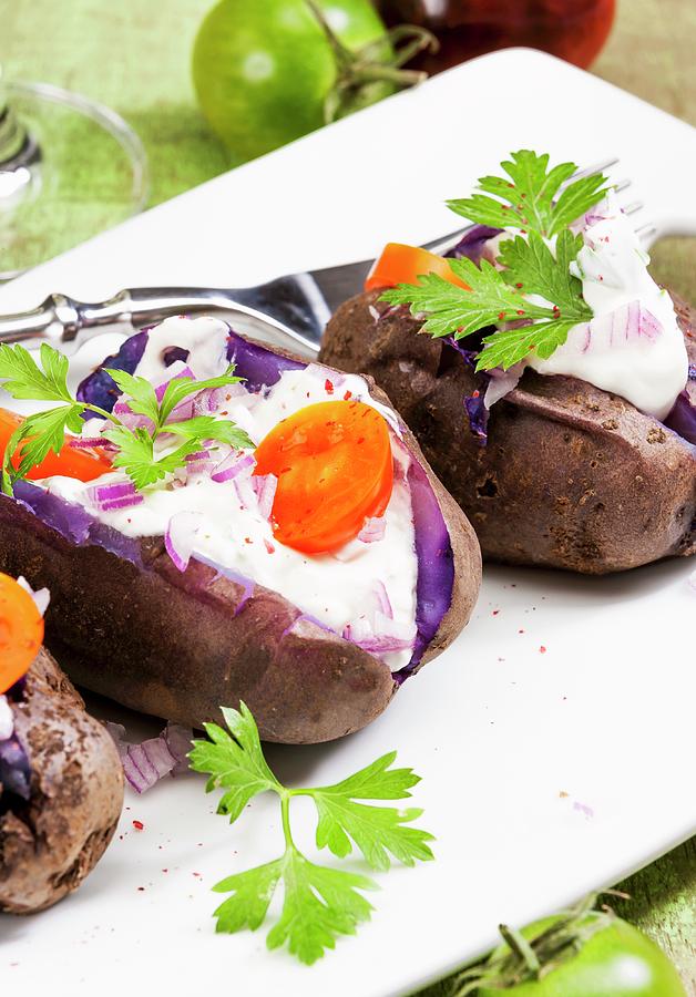 Purple Baked Potatoes With Sour Cream, Onions And Tomatoes Photograph by Birgit Twellmann