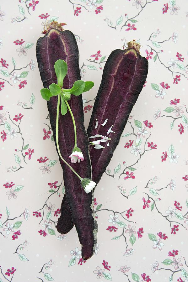 Purple Carrots With Daisies On A Piece Of Floral Patterned Paper Photograph by Martina Schindler