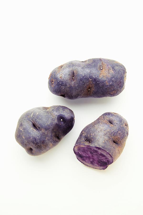 Purple Potatoes On A White Surface Photograph by Miriam Rapado