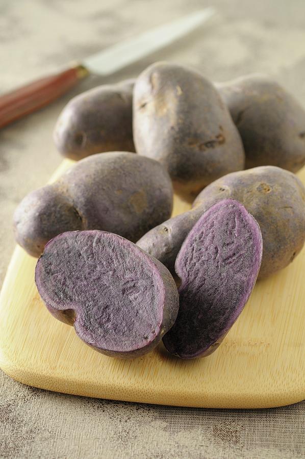 Purple Potatoes On A Wooden Board Photograph by Jean-christophe Riou
