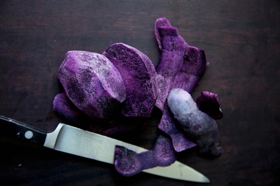 Purple Potatoes With Knife On A Dark Background Photograph by Andre Baranowski