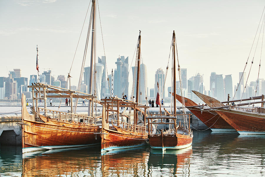 Qatar, Ad-dawhah, Doha, Arabian Peninsula, Traditional Wooden Dhow Sailing Boats In Front Of The Doha City Skyline Digital Art by Richard Taylor