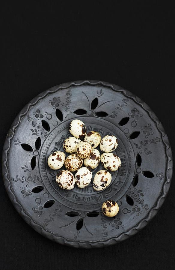Quail Eggs In A Black Metal Bowl Against A Black Background Photograph by Adel Bekefi