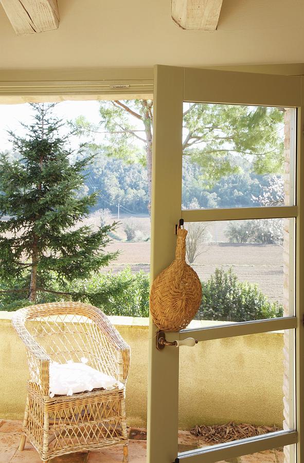 Raffia Fan Hung On Open Balcony Door With View Of Landscape Photograph by Jos-luis Hausmann