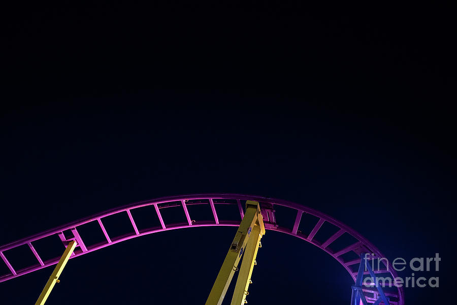 Rails of a roller coaster, blue night sky background. Photograph by Joaquin Corbalan