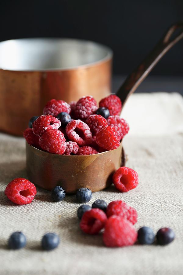 Raspberries And Blueberries In A Copper Pot Photograph by Eva Lambooij