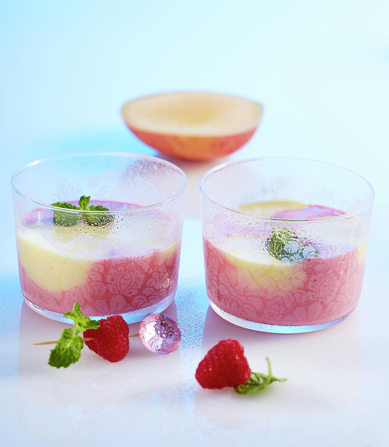 Raspberry And Mango Smoothie In Two Small Glasses With Yoghurt, Milk And Lemon Balm Photograph by Teubner Foodfoto