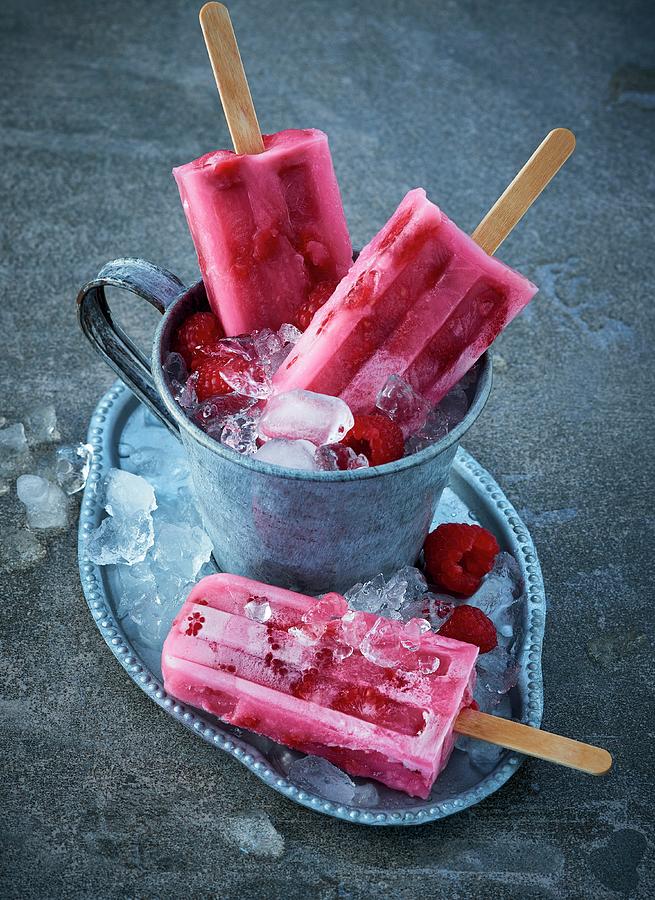 Raspberry Ice Lollies On Crushed Ice Photograph by Stefan Schulte-ladbeck