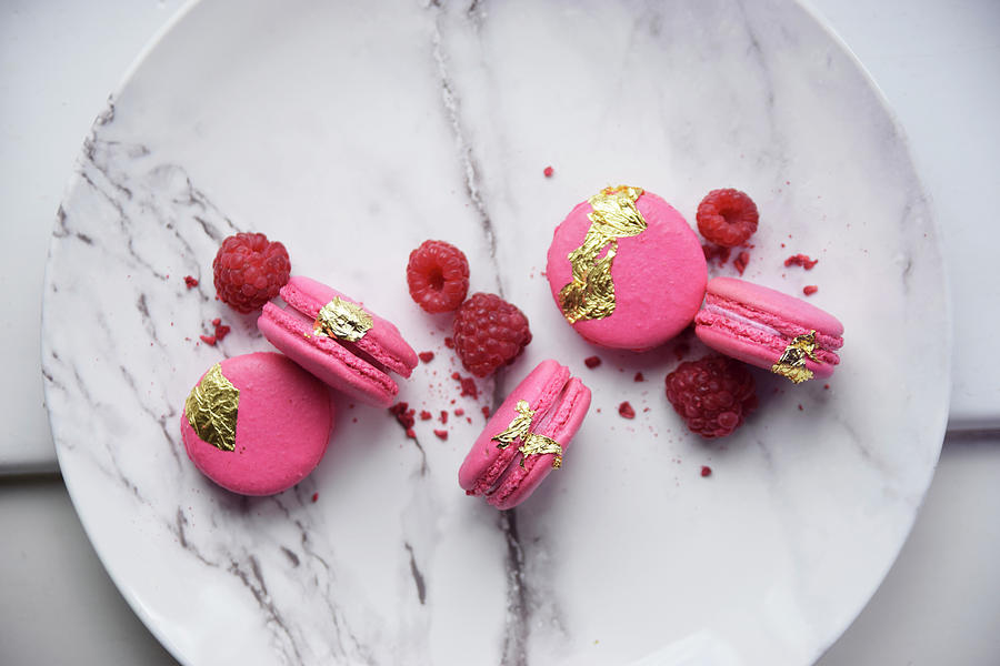 Raspberry Macaroons With Gold Leaf And Fresh Raspberries Photograph by So Schmeckt Liebe