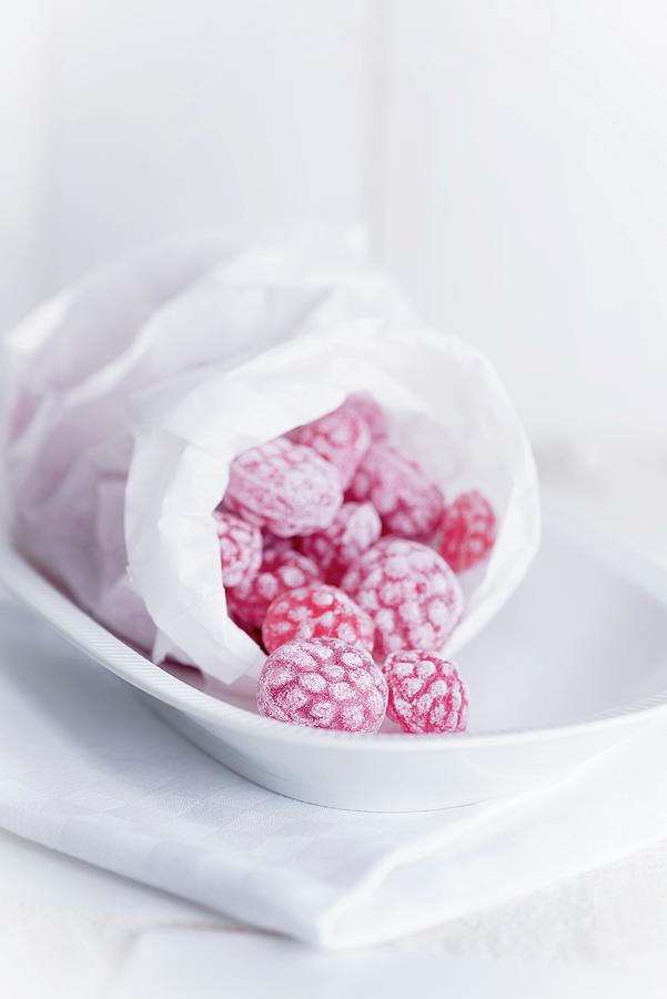 Raspberry Sweets In A Bread Bag On A White Dish Photograph by Julian Winkhaus