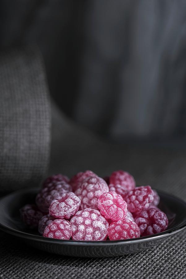 Raspberry Sweets In A Grey Plate On A Piece Of Grey Fabric Photograph by Julian Winkhaus