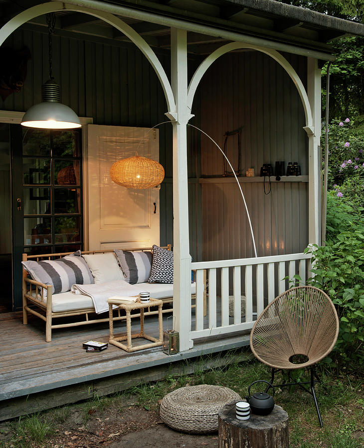 Rattan Couch And Arc Lamp On Wooden Veranda Photograph by James Stokes