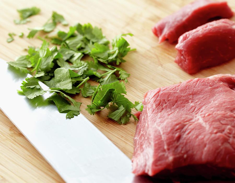 Raw Beef And Chopped Cilantro On A Wooden Cutting Board Photograph by Edward Thomas