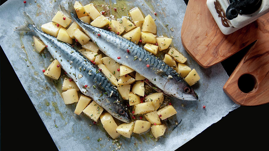 Raw Mackerel On A Potato Bed In Parchment Paper Photograph by Mmirkophoto