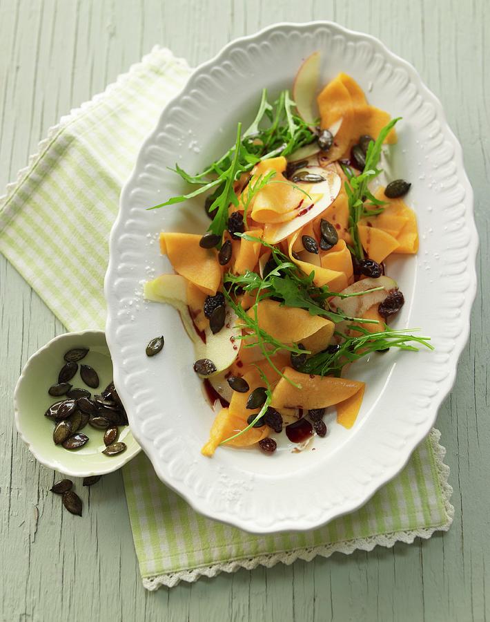 Raw Marinated Pumpkin Salad With Rocket, Apple, Pumpkin Seeds And Pumpkin Seed Oil Photograph by Jan-peter Westermann