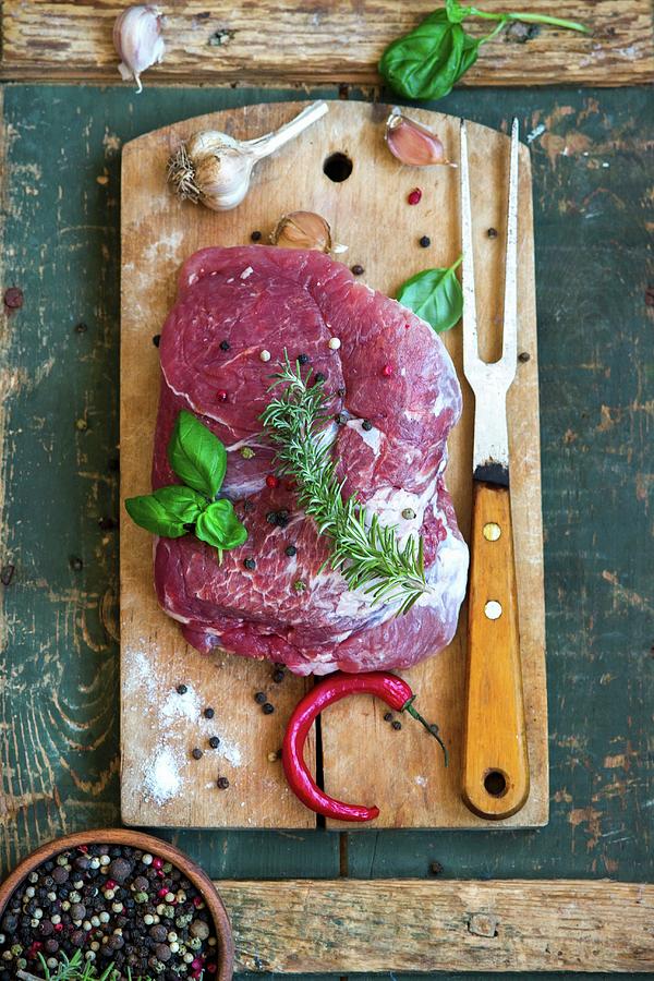 Raw Pork With Herbs, Garlic, Pepper And Chilli On A Chopping Board Photograph by Irina Meliukh