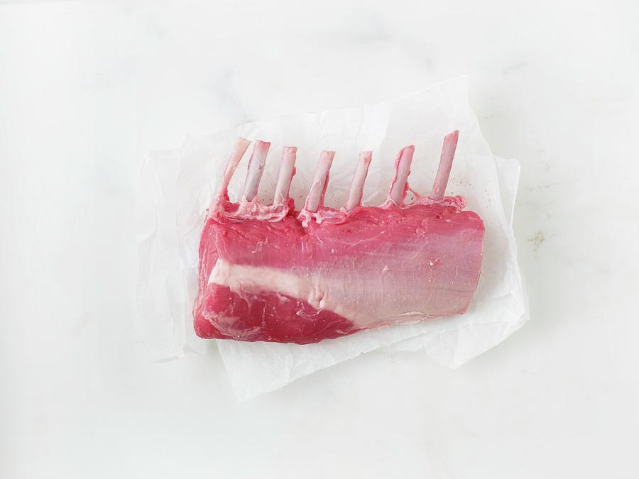 Raw Rack Of Lamb On A Piece Of Parchment Paper Photograph by Myles New