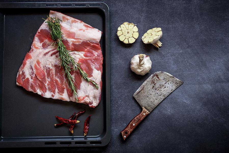 Raw Ribs With Rosemary, Chilies, Garlic, And A Meat Cleaver Photograph by Eduardo Lopez Coronado