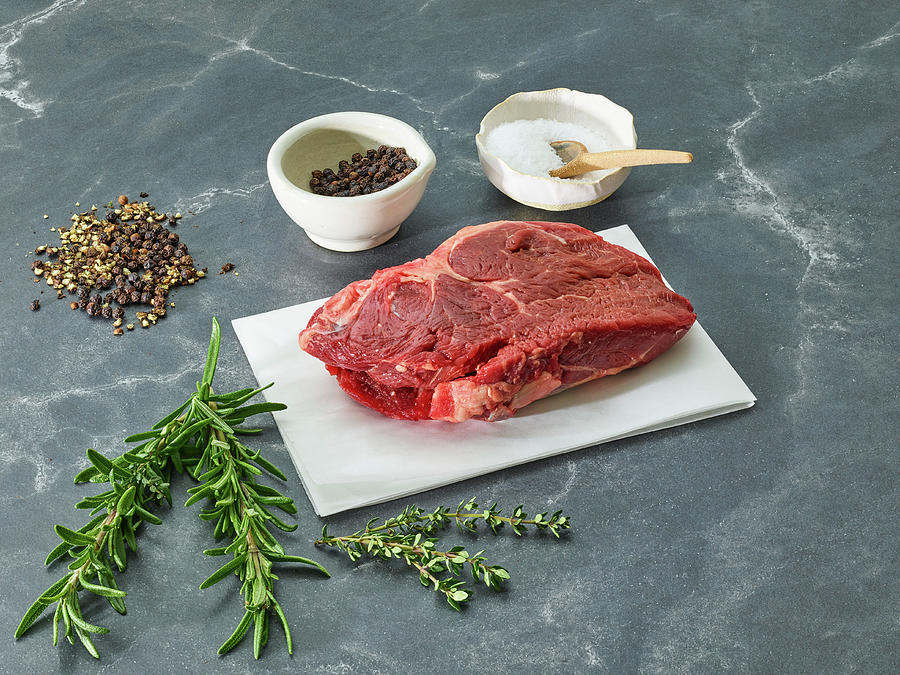 Raw Sirloin Steak On A Piece Of Paper Surrounded By Herbs And Spices ...