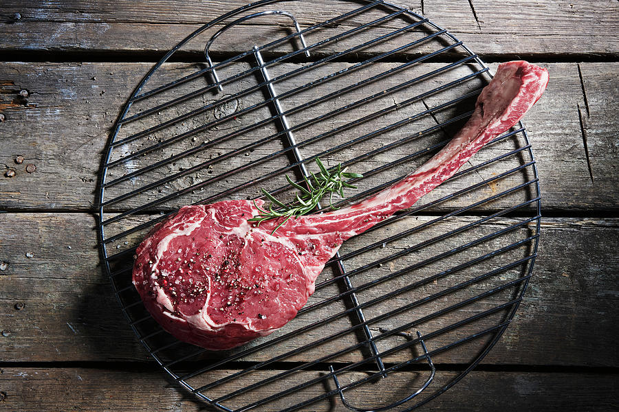 Raw Tomahawk Steak On A Grill Grid top View Photograph by Misha Vetter