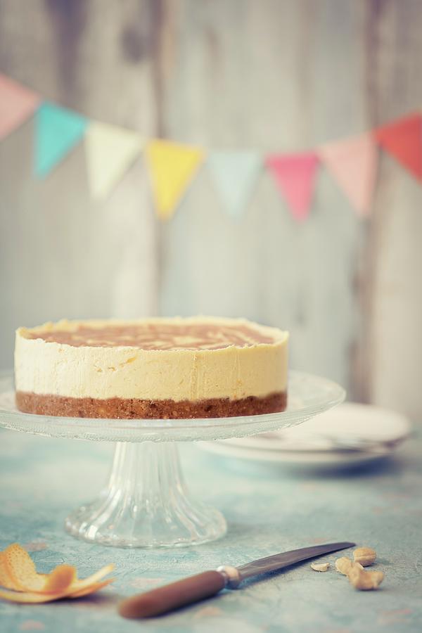 Raw Vegan Cheesecake On A Cake Stand With Bunting In The Background Photograph by Jan Wischnewski