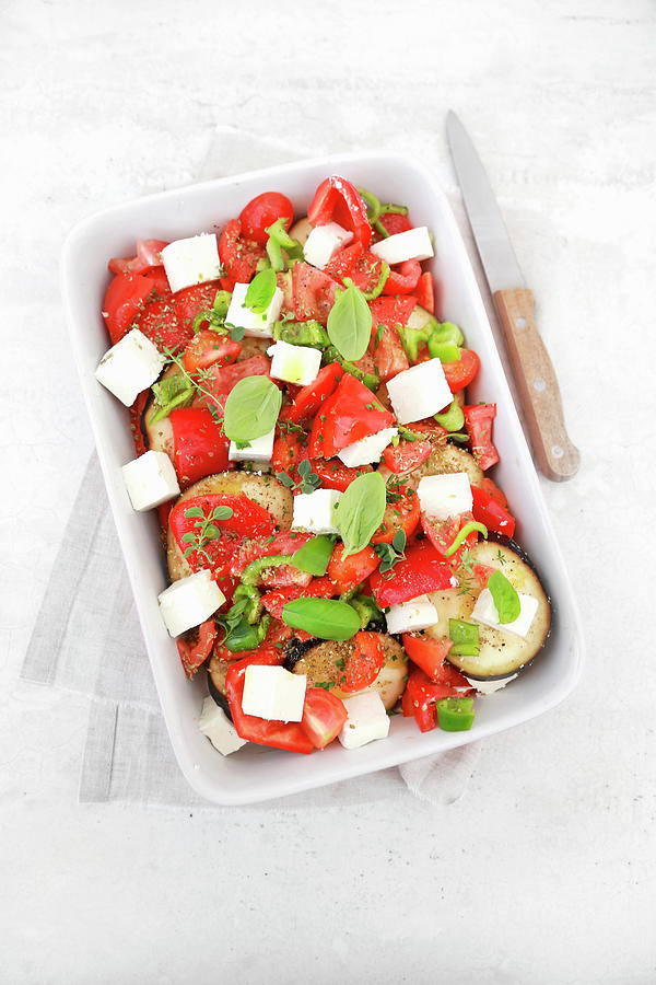 Raw Vegetable Pan Ready For The Oven Tomatoes Peppers Aubergines Feta Cheese And Aromatic Herbs Photograph by Claudia Gargioni