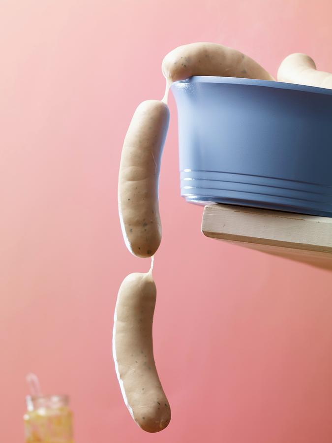Raw White Sausages Hanging Over The Edge Of A Blue Plastic Bowl Photograph by Studio R. Schmitz