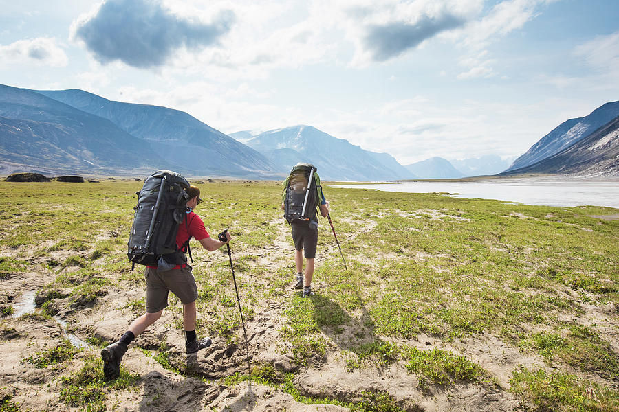 Rear View Of Backpackers Hike Over Arctic Tundra In Akshayak Pass ...