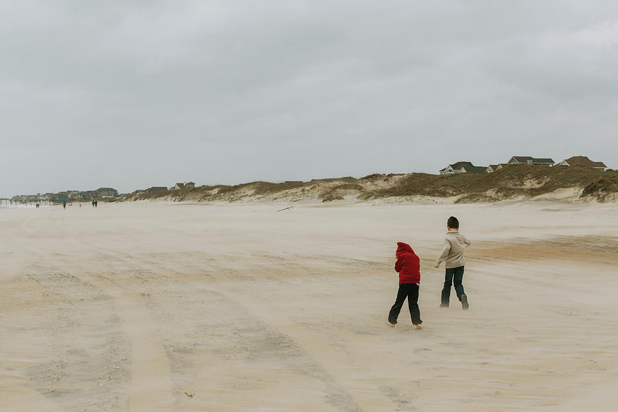 Nature Photograph - Rear View Of Brothers Running At Beach Against Cloudy Sky by Cavan Images