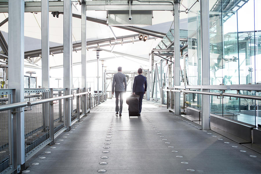 Rear View Of Businessmen With Luggage Walking In Transportation Building Photograph by Cavan Images Rear View Of Businessmen With Luggage Walking In Transportation Building Photograph by Cavan Images
