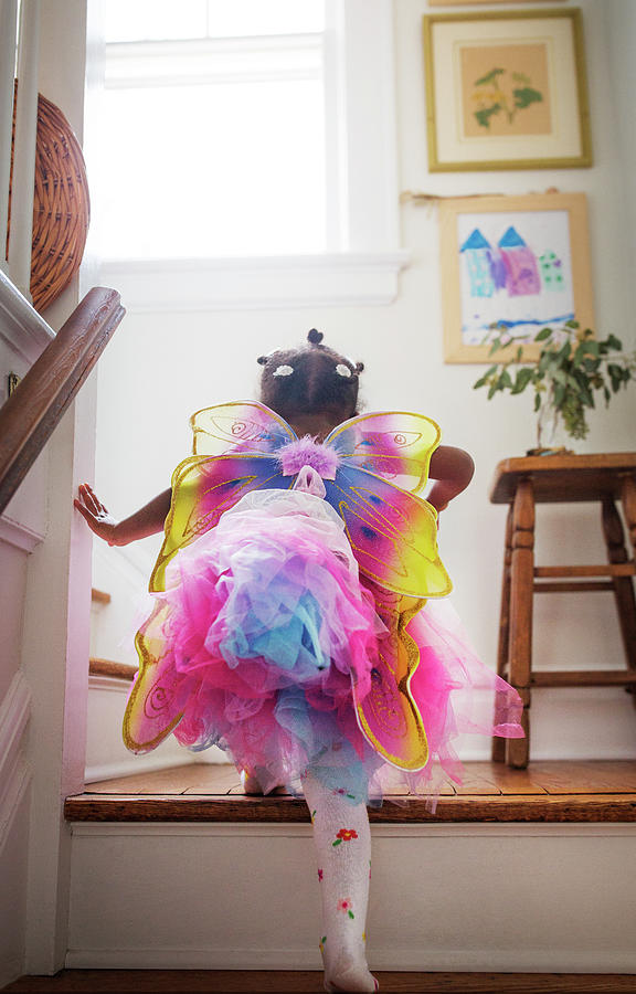 Fantasy Photograph - Rear View Of Girl In Fairy Costume Moving Up Steps At Home by Cavan Images